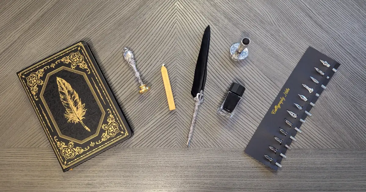Elegant black and gold writing set with a vintage quill pen, ink bottle, wax seal stamp, calligraphy nibs, and ornate journal on a wood surface — symbolizing A. K. Folsom's imprint brand and classic publishing aesthetic.